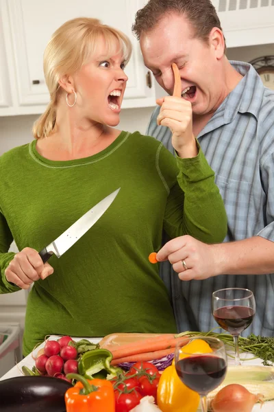 Homem fica muito perto da esposa cortando comida — Fotografia de Stock