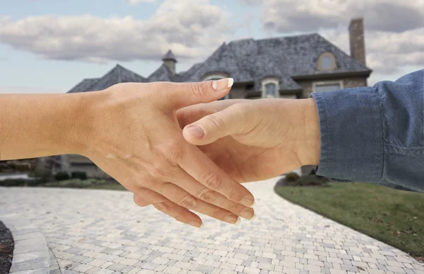 Man en vrouw hand schudden, voorkant van huis — Stockfoto