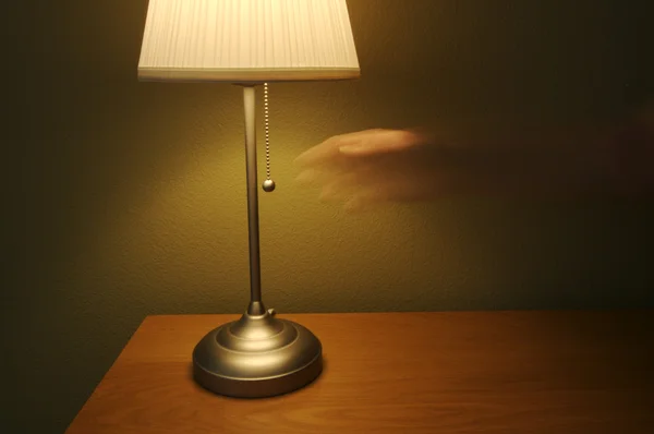 Lampa och bord med avspeglade hand — Stockfoto