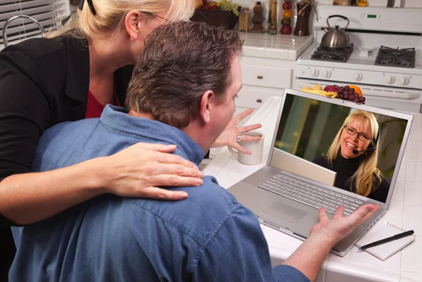 Пара с ноутбуком с женщиной на экране — стоковое фото