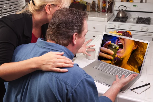 Casal usando laptop com dinheiro na tela — Fotografia de Stock