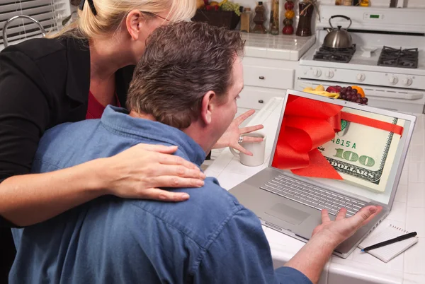 Ζευγάρι χρησιμοποιώντας φορητό υπολογιστή με χρήματα στην οθόνη — Φωτογραφία Αρχείου