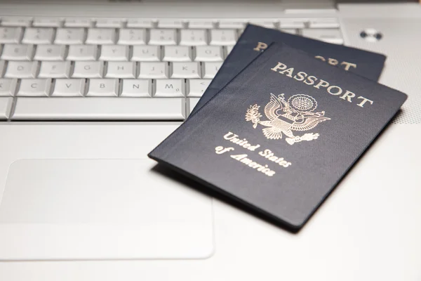 Resumen de dos pasaportes en un ordenador portátil — Foto de Stock