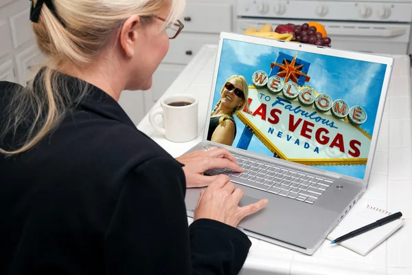 Mulher na cozinha usando laptop com Las Vegas Entre na tela — Fotografia de Stock