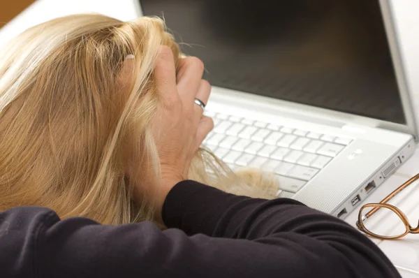 Frustrovaný žena drží hlavu v rukou pomocí přenosného počítače — Stock fotografie