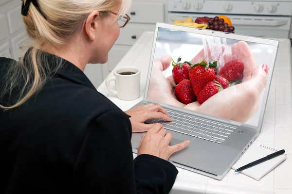 Mädchen benutzt Laptop mit Obst auf dem Bildschirm — Stockfoto