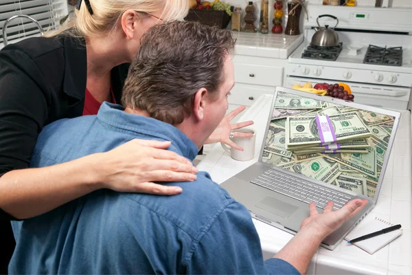 Пара на кухне с помощью ноутбука, чтобы заработать или выиграть деньги — стоковое фото
