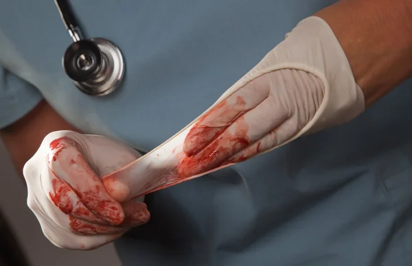 Лікар з криваві хірургічні рукавички — стокове фото