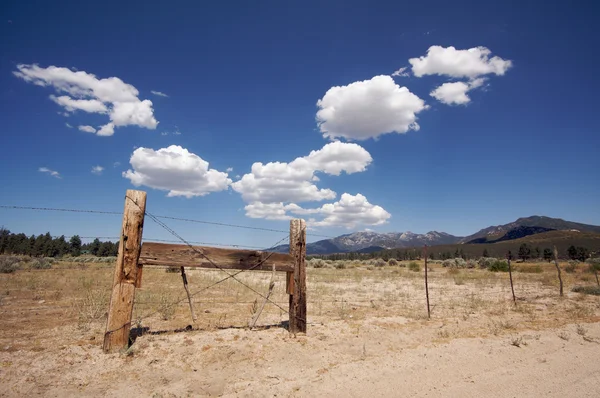 Åldern staket, fält och moln — Stockfoto