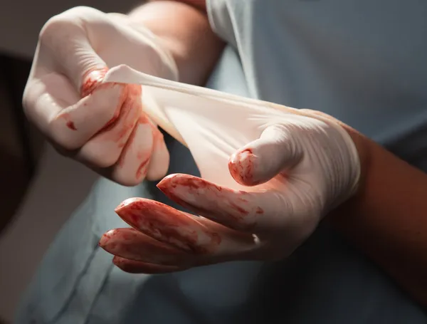 Médico con guantes quirúrgicos sangrientos —  Fotos de Stock