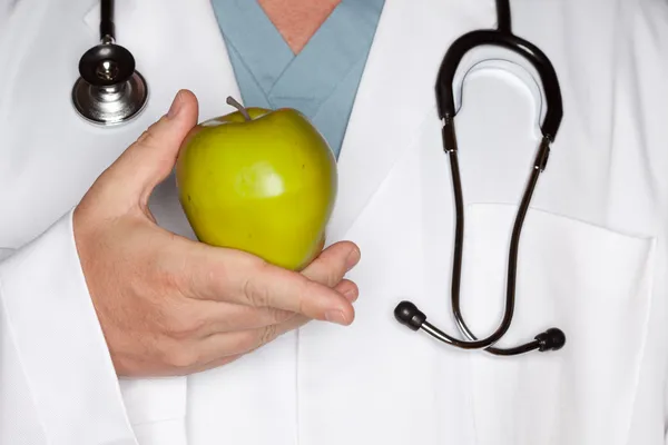 リンゴを保持聴診器で医師 — ストック写真