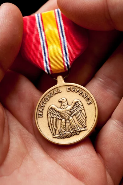 Hombre sosteniendo medalla de guerra de defensa nacional —  Fotos de Stock