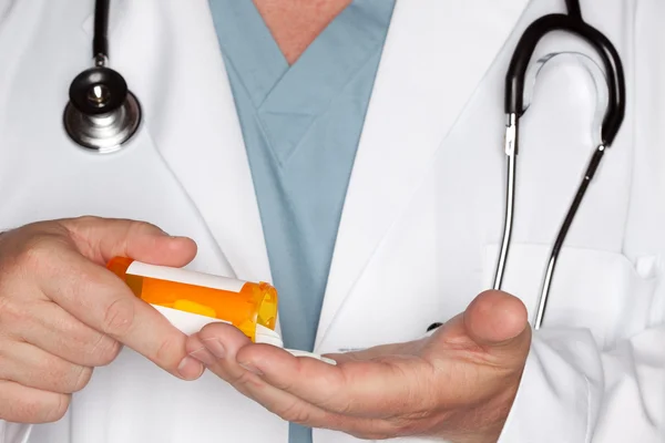 Доктор крупным планом вливает таблетки в руку — стоковое фото