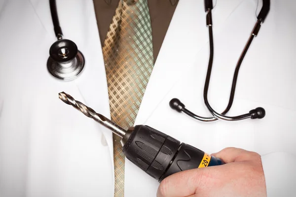 Доктор со стетоскопом держит очень большую дрель — стоковое фото