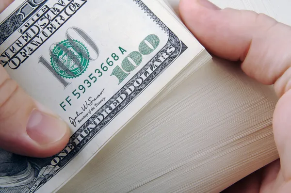 Man fanning grote stapel geld — Stockfoto