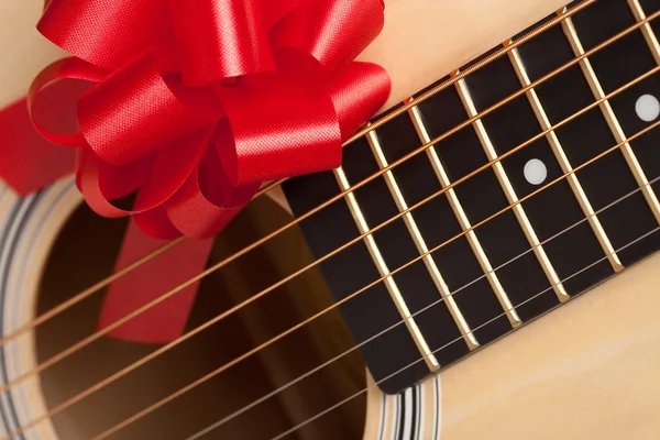 Primer plano de guitarra con lazo de cinta roja — Foto de Stock