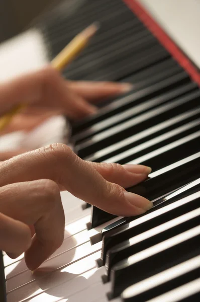 Mulher tocando piano digital com lápis — Fotografia de Stock