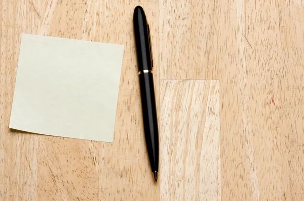 Στυλό και post σημειώνει μαξιλάρι κατά ξύλο — Φωτογραφία Αρχείου
