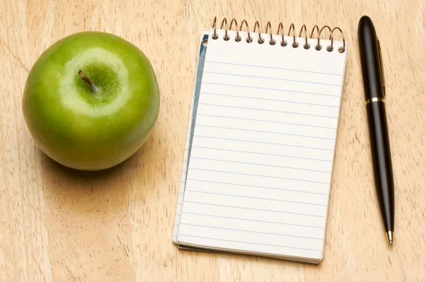 Στυλό, χαρτί και μήλο σε ξύλο — Φωτογραφία Αρχείου