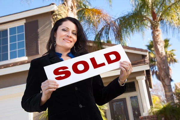 Frau mit verkauftem Schild vor Haus — Stockfoto