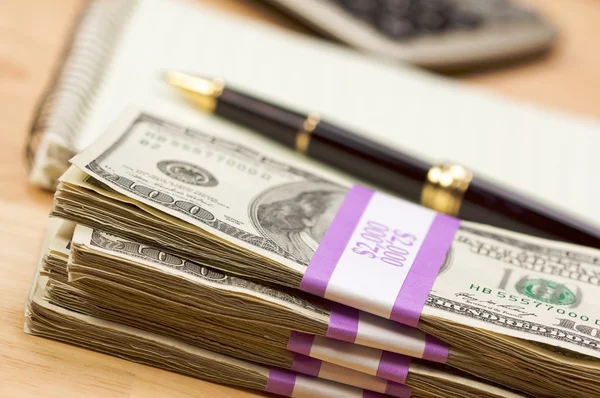 Pilha de dinheiro, calculadora, almofada de papel — Fotografia de Stock