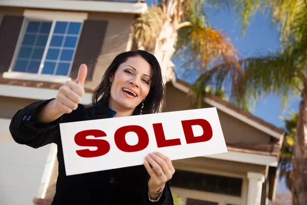 Hispanische Frau und verkaufte Immobilienschild — Stockfoto