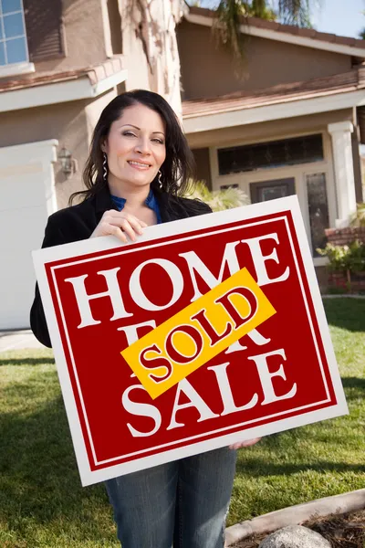Σπίτι και γυναίκα που κρατά πωλείται σπίτι σημάδι — Φωτογραφία Αρχείου