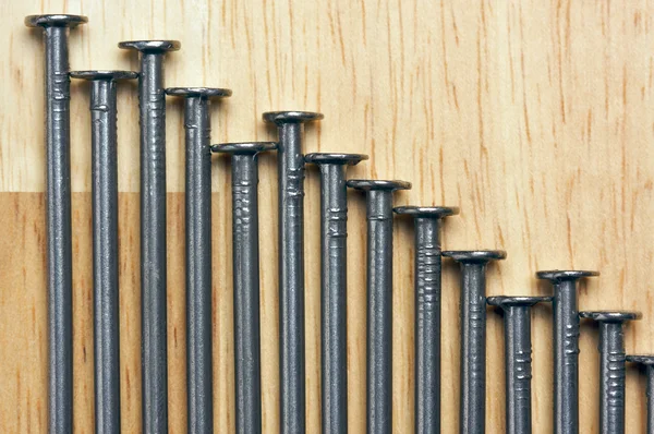 Gráfico declinante de unhas em uma madeira — Fotografia de Stock