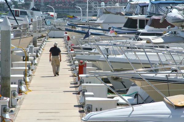 Man lopen het dock omringd door boten — Stockfoto