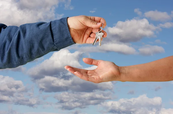 Het overhandigen van de sleutels op wolken — Stockfoto