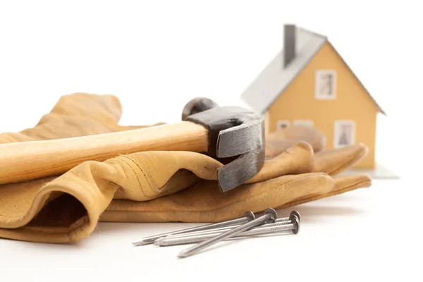 Hammer, Gloves, Nails and House on White — Stock Photo, Image