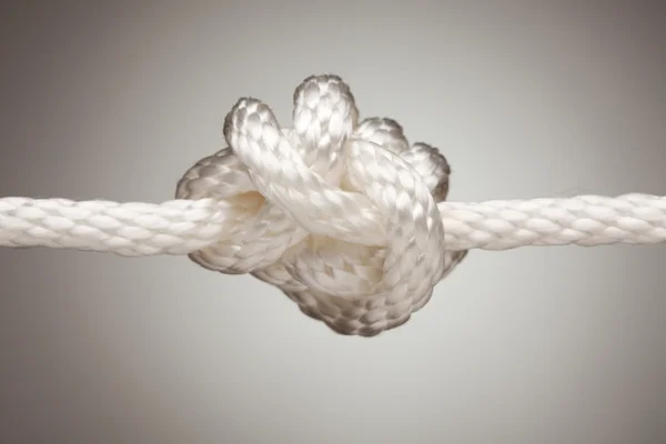 スポットの明るい背景上のナイロン ロープの結び目 — ストック写真
