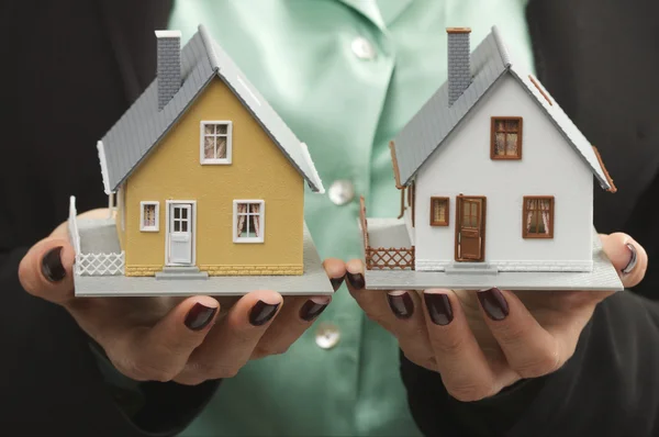 Två modell hus i kvinnliga händer — Stockfoto