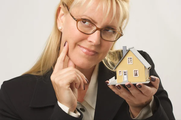 Myšlení ženy držící model domu — Stock fotografie