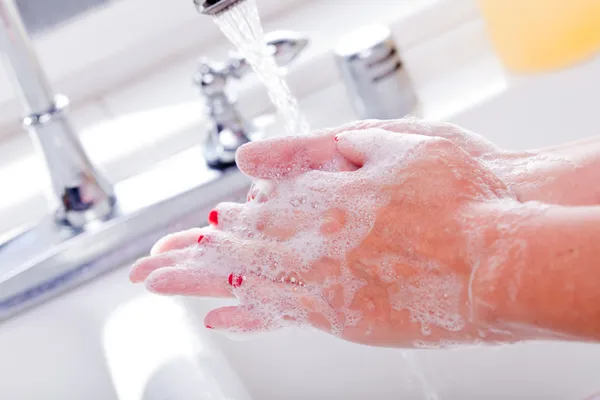 Femme se laver les mains dans l'évier de la cuisine . — Photo
