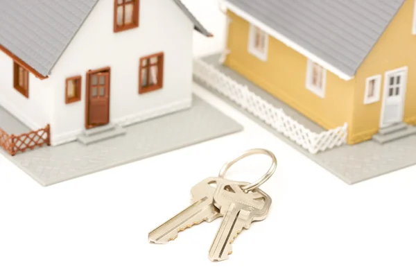 Ключи и модельные дома на белом — стоковое фото