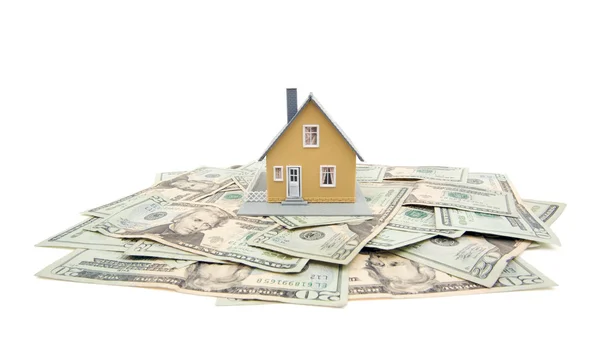 Модель дома и стопка денег на белом — стоковое фото
