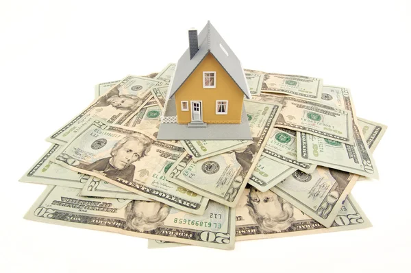 Модель дома и стопка денег на белом — стоковое фото