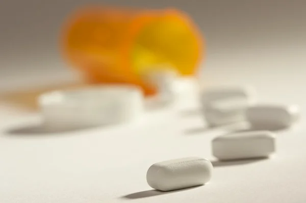Pillen en gevallen fles op gradatie — Stockfoto