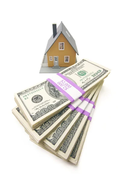 Domu i stosy pieniędzy na białym tle — Zdjęcie stockowe