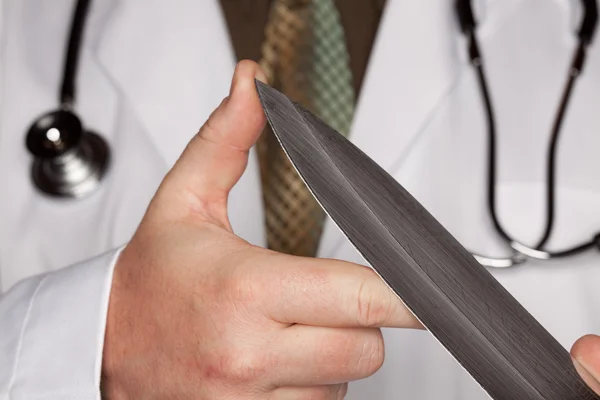 Доктор держит острый кухонный нож — стоковое фото