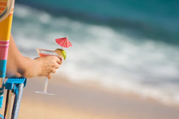 Γυναίκα χαλαρώνοντας στην παραλία με ποτό — Φωτογραφία Αρχείου