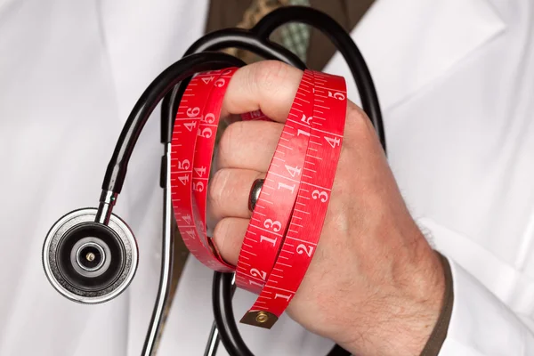 Le médecin tient un stéthoscope, un ruban à mesurer — Photo
