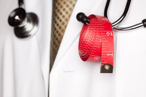 Médico com estetoscópio e fita de medição vermelha . — Fotografia de Stock