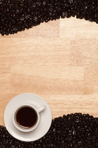 Feijão e xícara de café torrados escuros — Fotografia de Stock