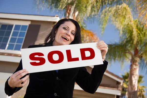 Happy Hispanic Woman Holds SOLD Sign Stock Photo