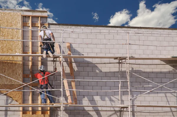 Carpinteiros trabalhando diligentemente na parede de tijolo — Fotografia de Stock
