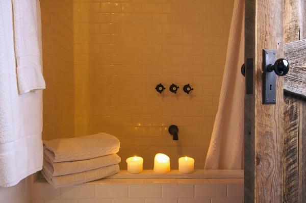 Rustikální koupelny scénu s ručníky a svíčky — Stock fotografie