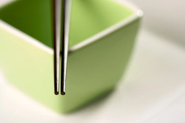 Yemek çubukları ve yeşil kase — Stok fotoğraf