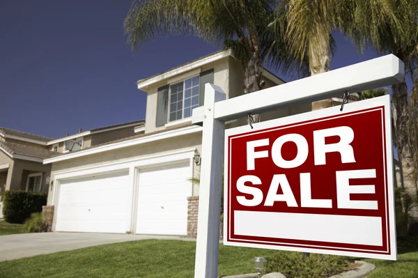 Красный для продажи недвижимости знак и дом — стоковое фото